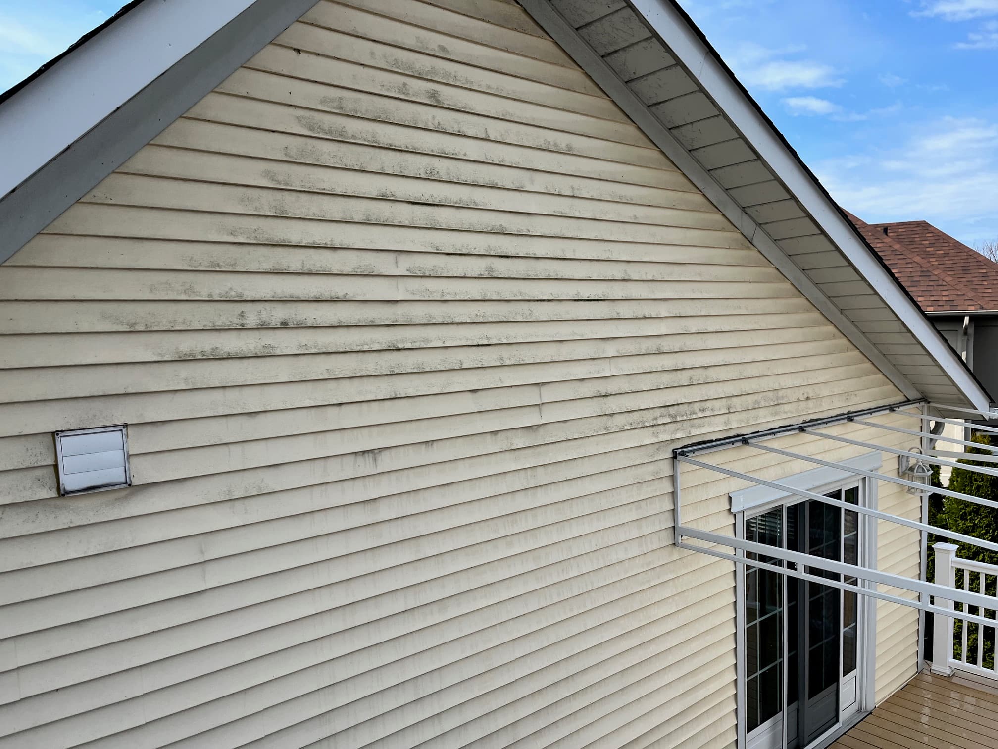 Soft washing before cleaning with visible siding buildup